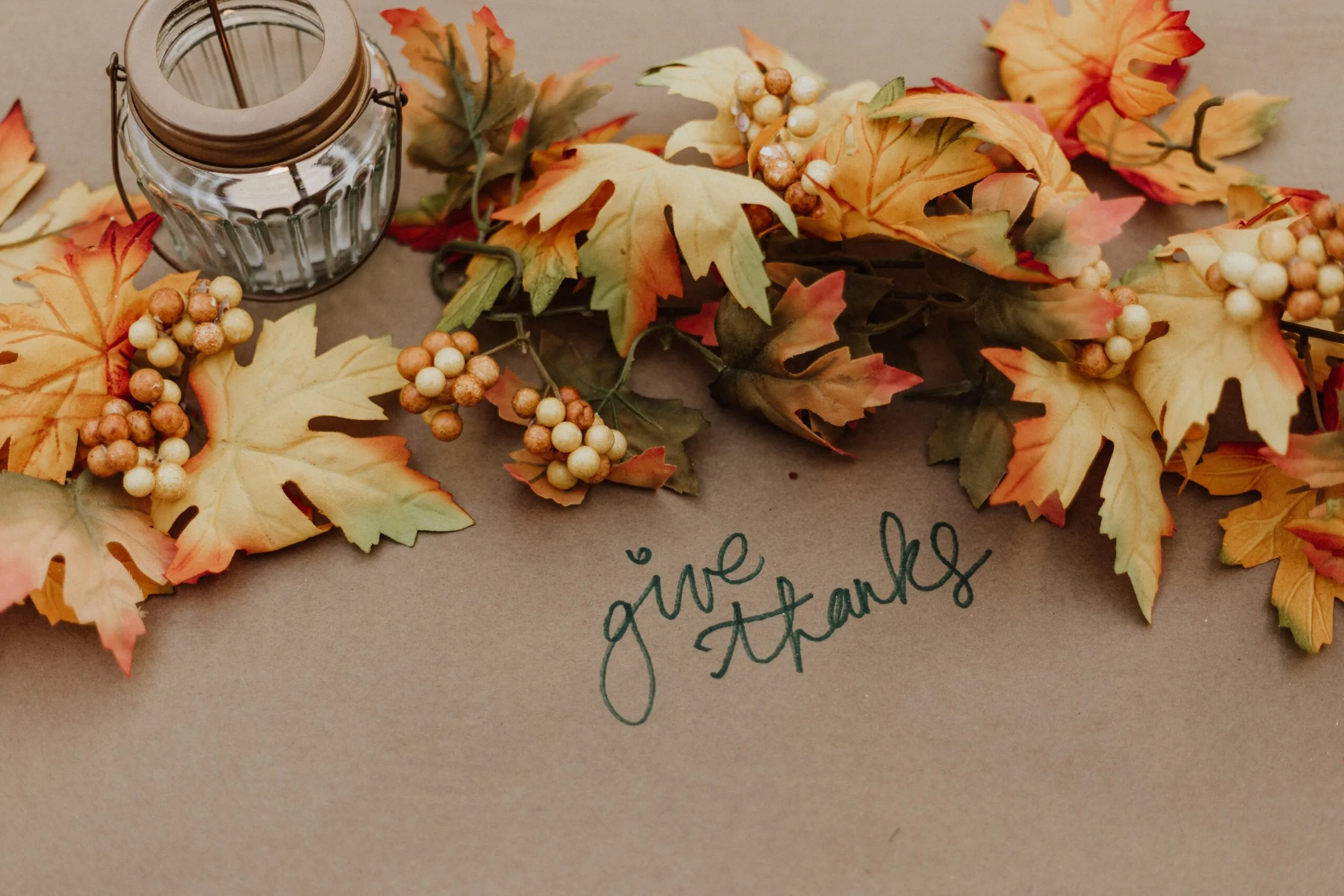 Fall leaves on a table with "give thanks"