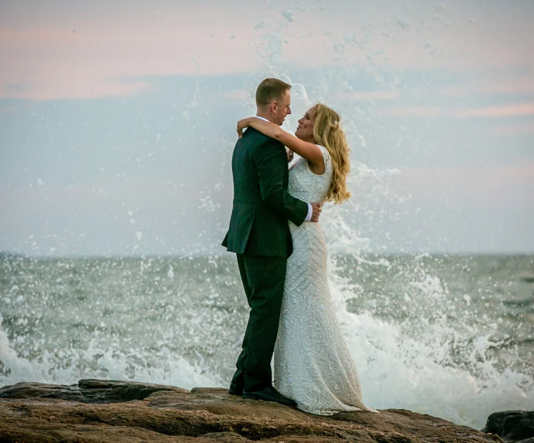 Couple posing in front of beach waves