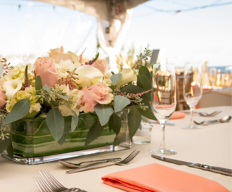 Floral centerpiece on table with glasses and silverware