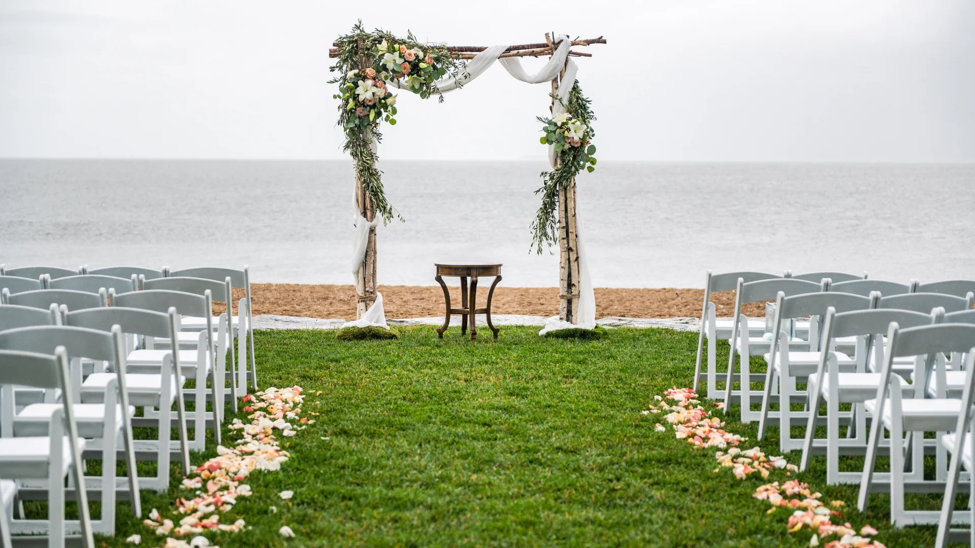Wedding arch on beach with chairs
