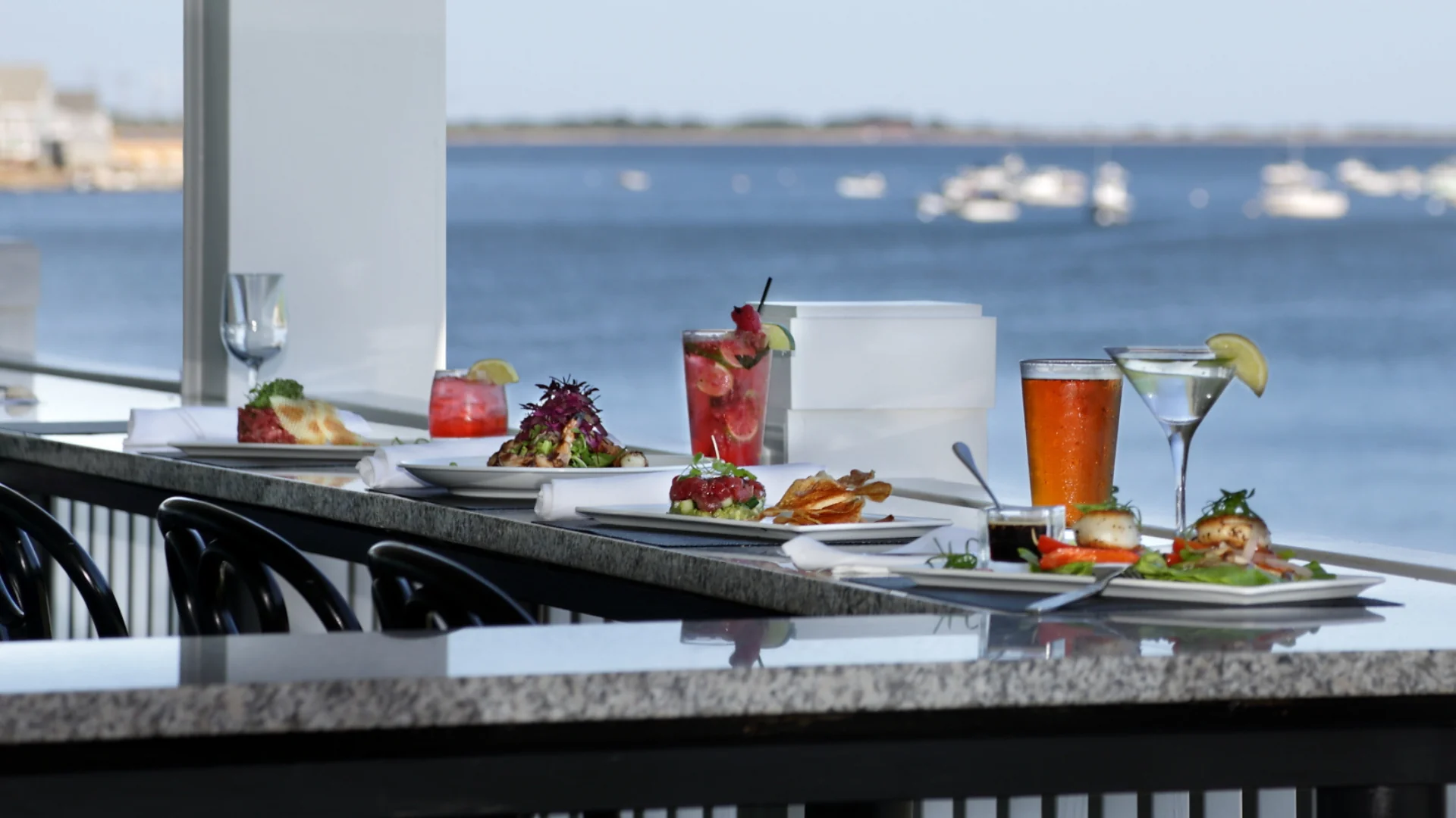 Food and drinks on plates with water in the background