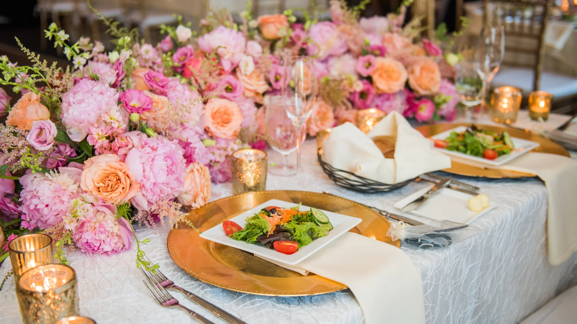 Flowers on a table with salads on a plate