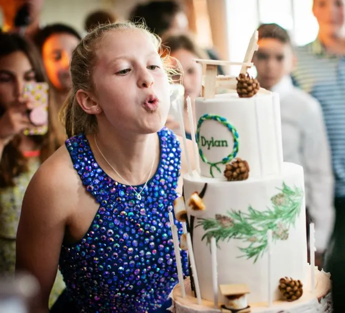 Girl blowing out candle on a cake