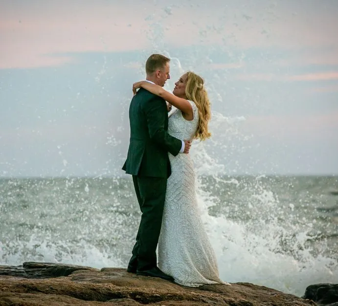 Married couple in front of ocean waves
