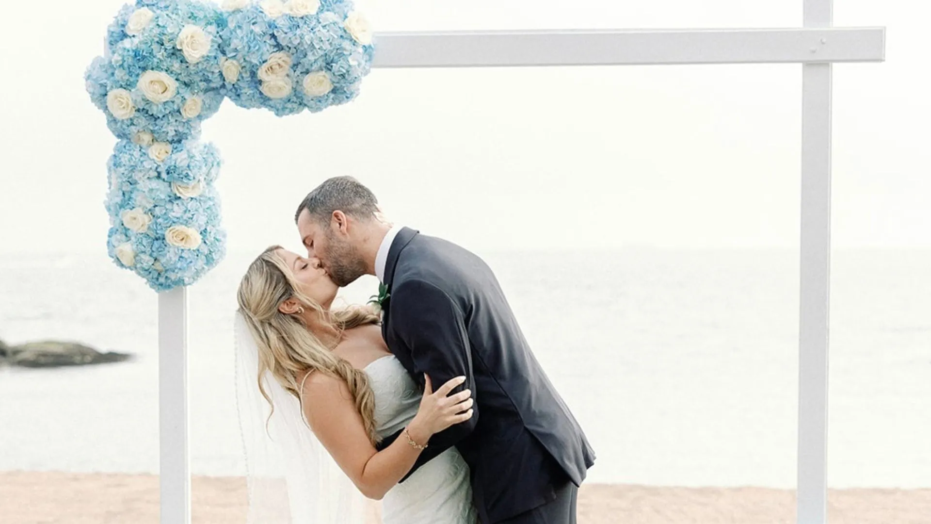Wedding Couple kissing under Ceremony Arch
