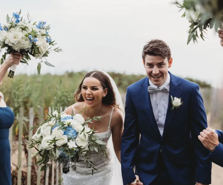 Bride holding flower bouquet and Groom on wedding day on beach