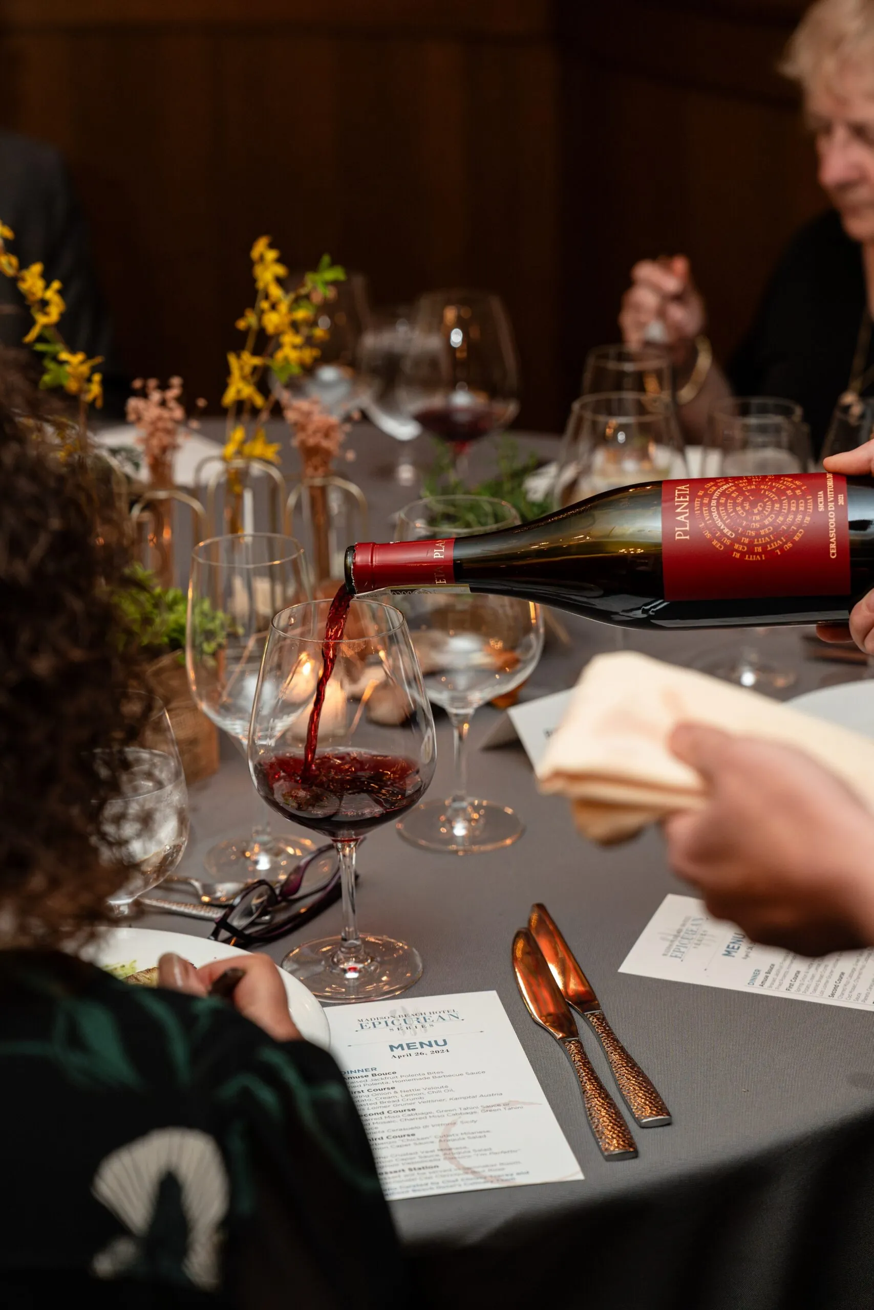 server pouring wine at dinner event